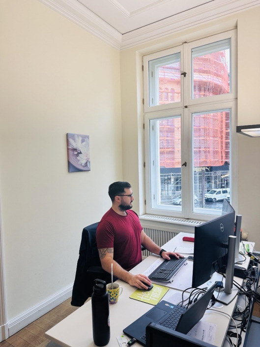 Ein Mitarbeiter an seinem Arbeitsplatz bei RAW-Partner in Berlin