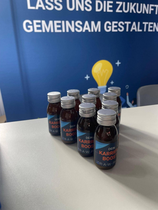 Flaschen mit Aufschrift Karriere Boost auf der Campus Connect Messe am Messestand von RAW-Partner
