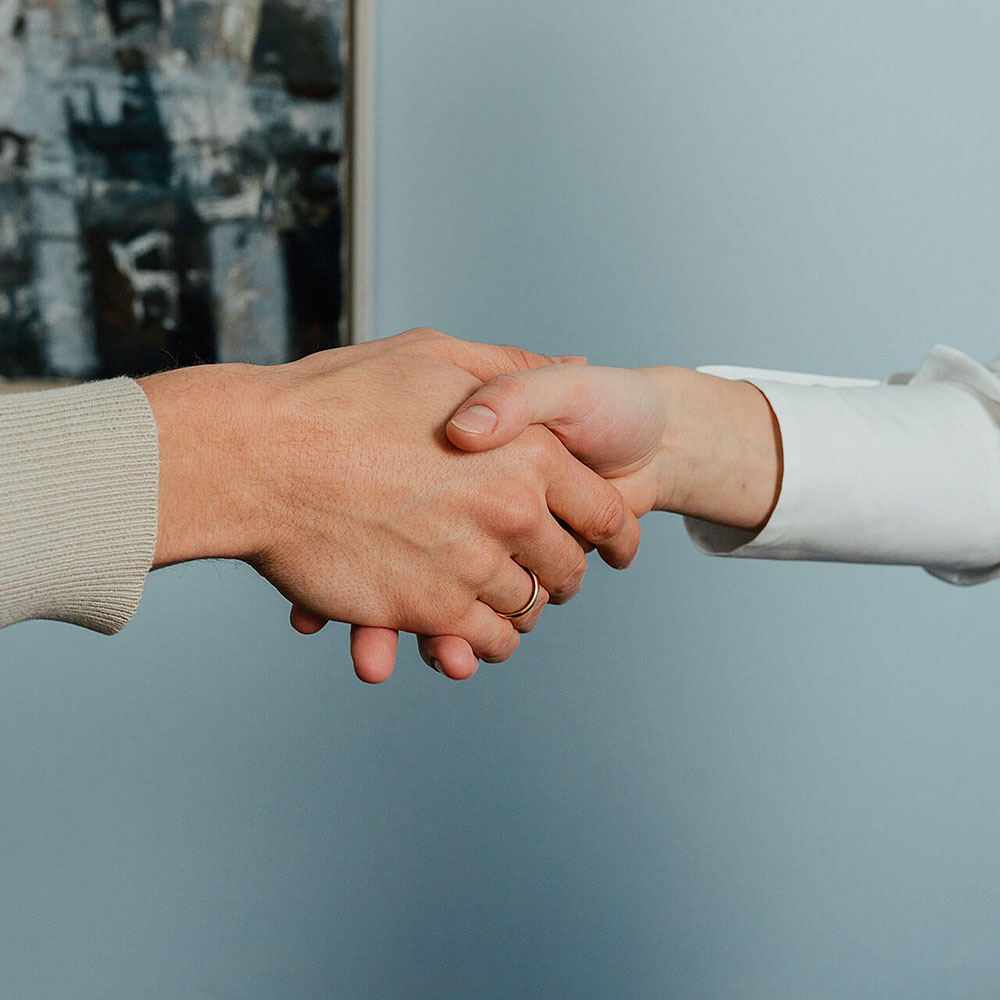 Zwei Personen schütteln sich die Hände